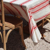 Red and white striped tablecloth on a wooden chair with a textured floor background