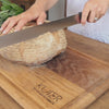 Person slicing though bread with long bread knife
