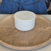Off white butter keeper filled with butter that is spreadable being demonstrated